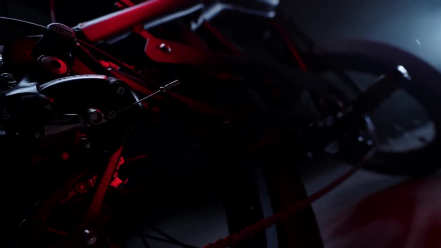 A motorcycle showcases its wheels and body against a black background
