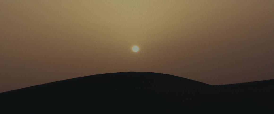 The sun setting behind a hill
