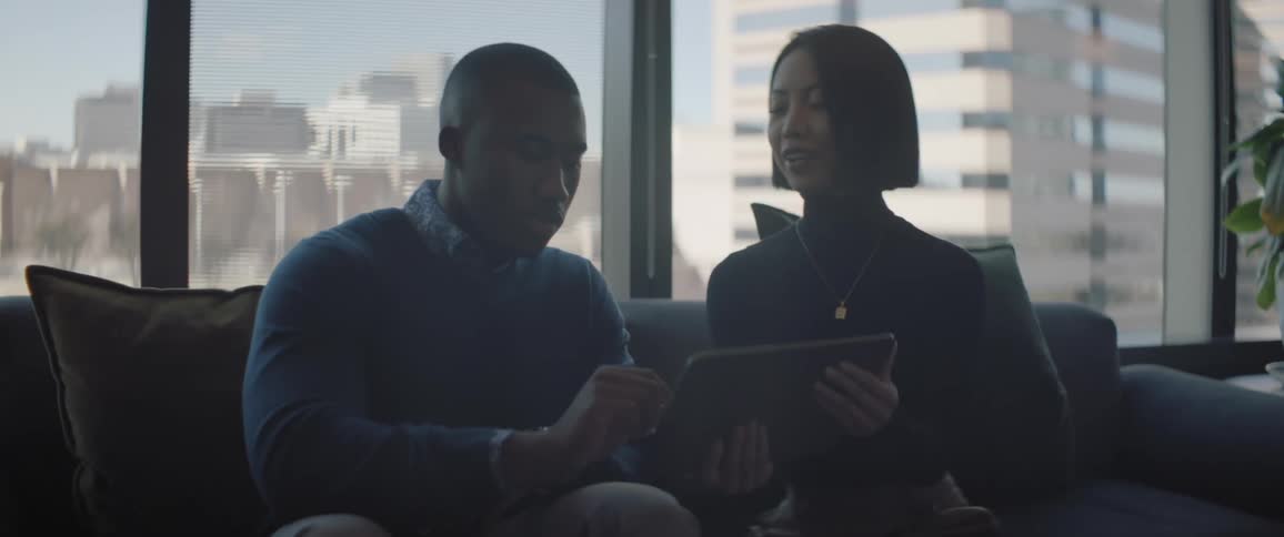 Coworkers have a conversation working on a tablet from the office