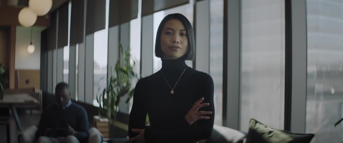 A clip of an asian lady putting on a black turtleneck