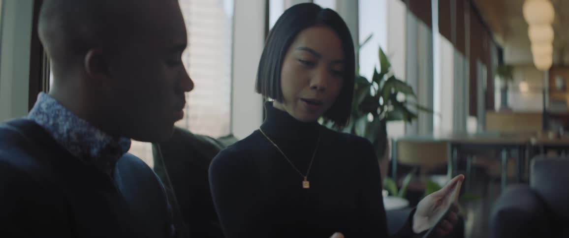 Two workers are talking while looking at a tablet