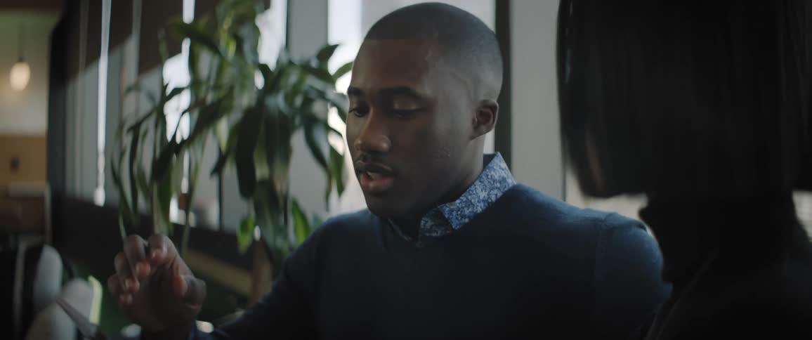 Coworkers sitting on a couch talking in the office