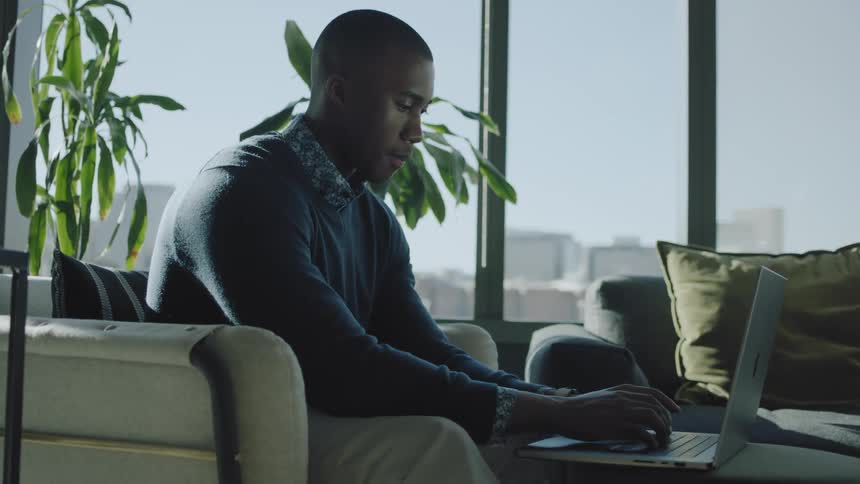A man is typing on his laptop