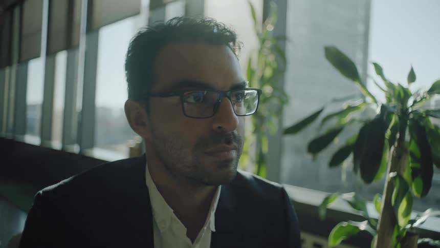 A man is sitting by the window