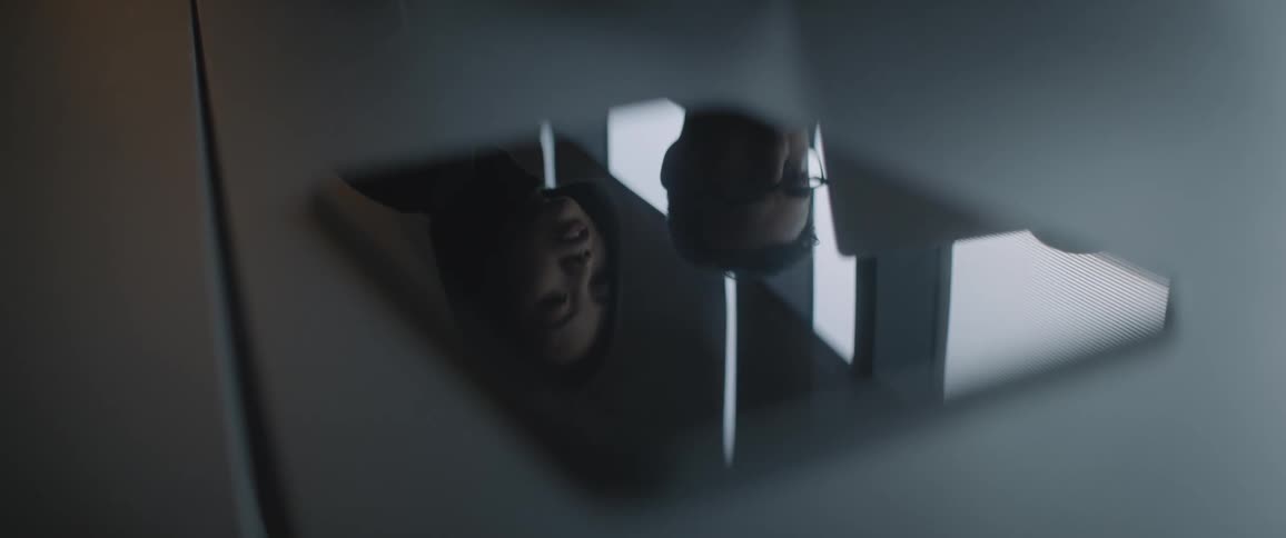 People reflected in a tablet screen on the table