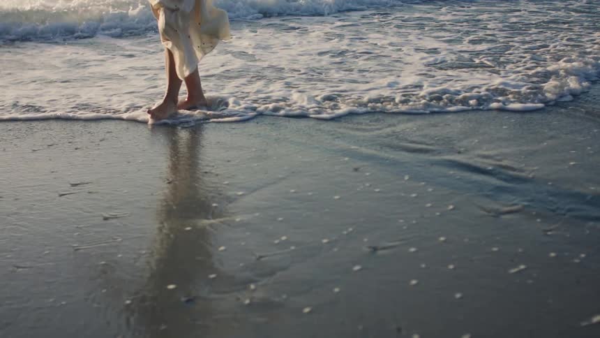 A woman is walking on the beach
