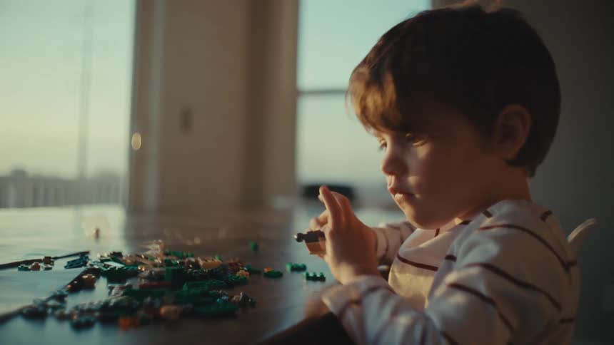 Boy playing alone with toys at home in the morning