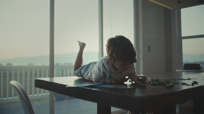 A boy reading a book lying on a table