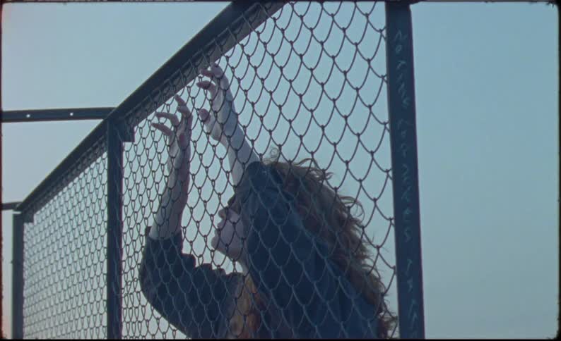 A woman is leaning on the fence