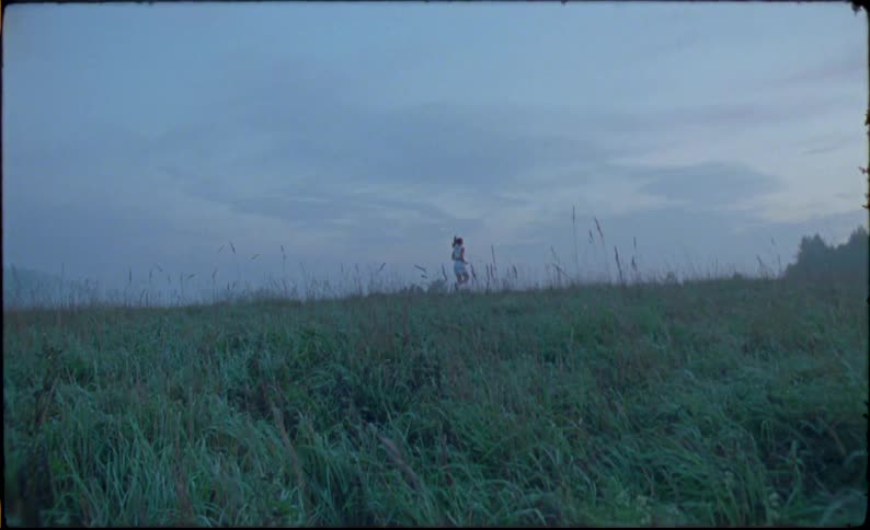 Young fit woman running over a treadmill in the countryside caught on vintage film