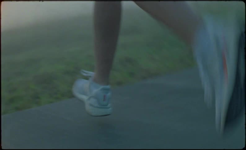 A woman is jogging through the fog