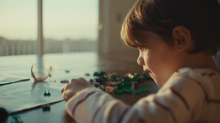 Boy playing alone with toys at home in the morning