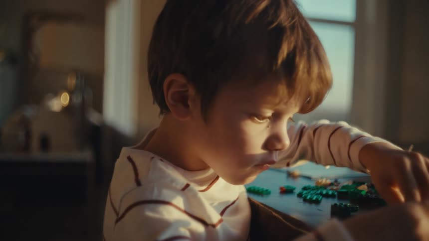 Boy playing alone with toys at home in the morning