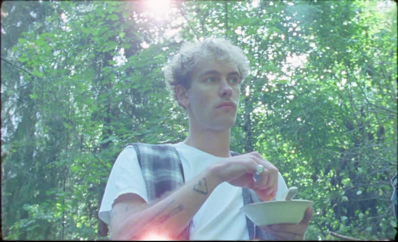 Young man eating cereal for breakfast in the forest