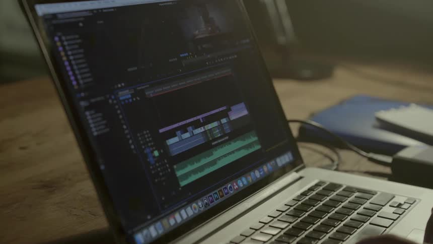 A creative video editor carefully synchronizes audio track levels for an independent film project