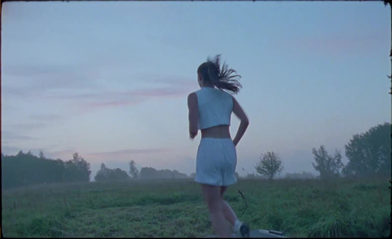 A woman is jogging on a treadmill outdoors