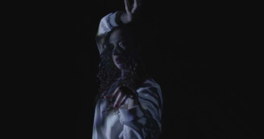 Young woman dancing under moiving lights