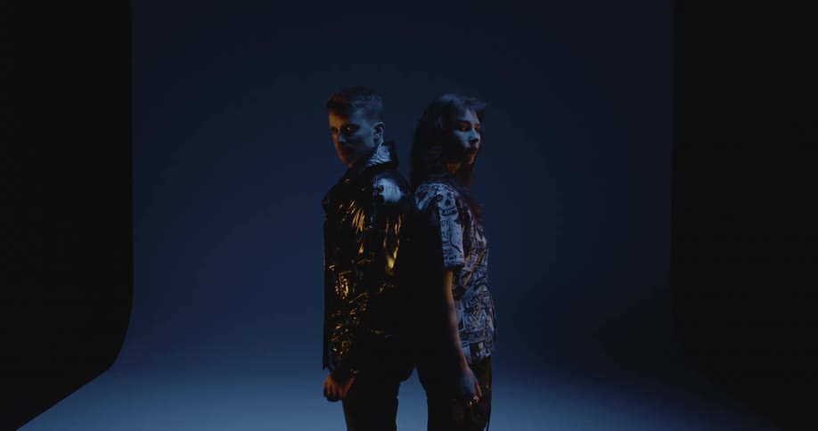 Two models are posing back to back