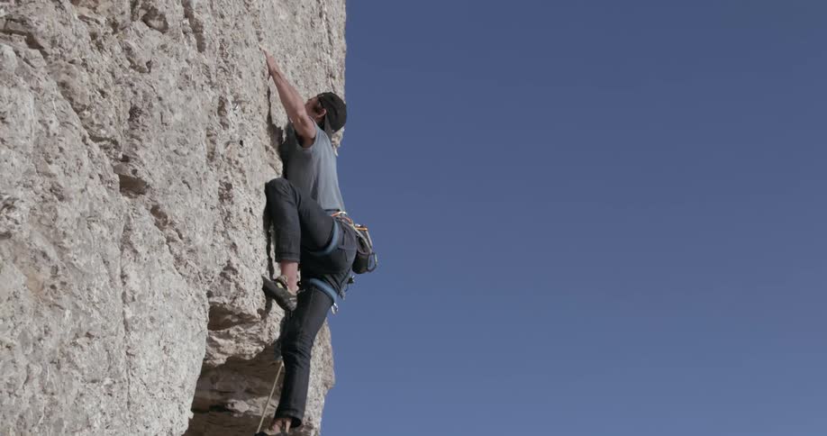 Man climbs a rock wall in the cliffs