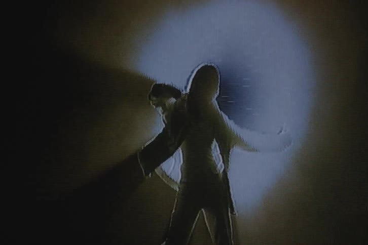 Silhouette of a woman dancing in front of a spotlight with vhs video distortion