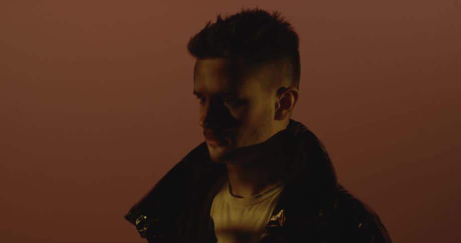 Young man wearing a leather jacket looks up