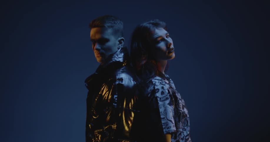 Two people an man and a woman standing and facing opposite direction