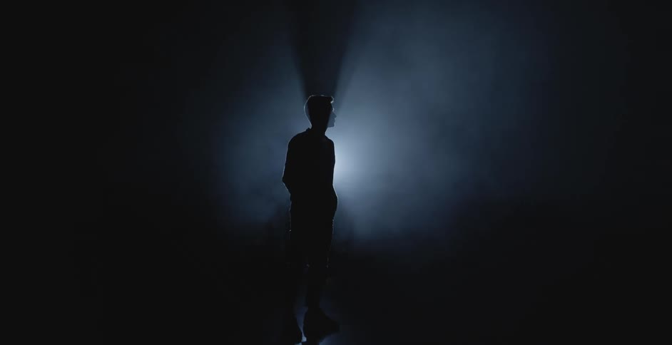 Silhouette of a man modeling in front of a spotlight