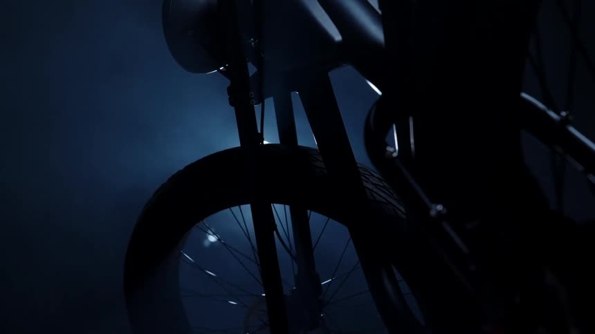 A bike parked in darkness near smoke