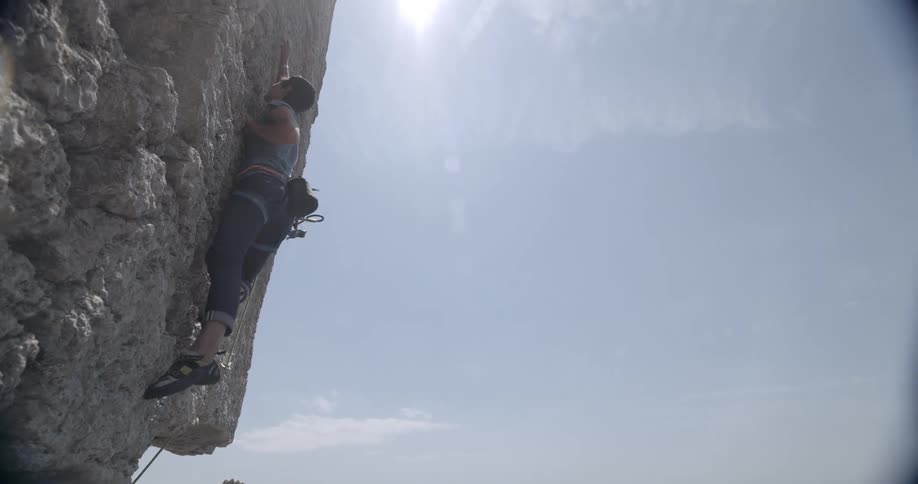 A man climbing a mountain wearing safety equipment