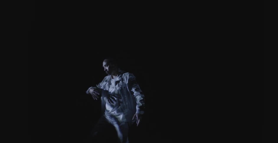 Man performs slow dance routine in darkness