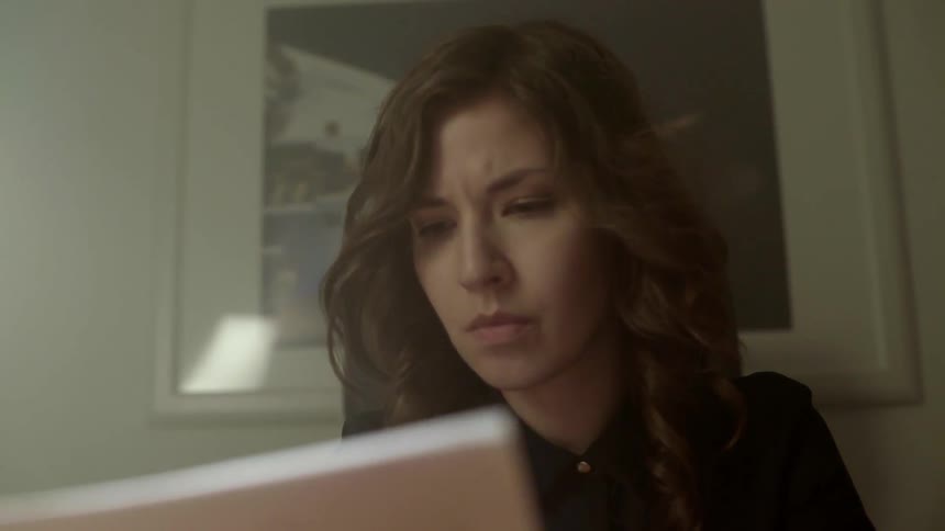 A creative writer reads through her printed manuscript looking for inspiration at night.