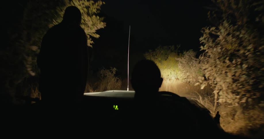 Rangers driving a jeep patrol the countryside at night