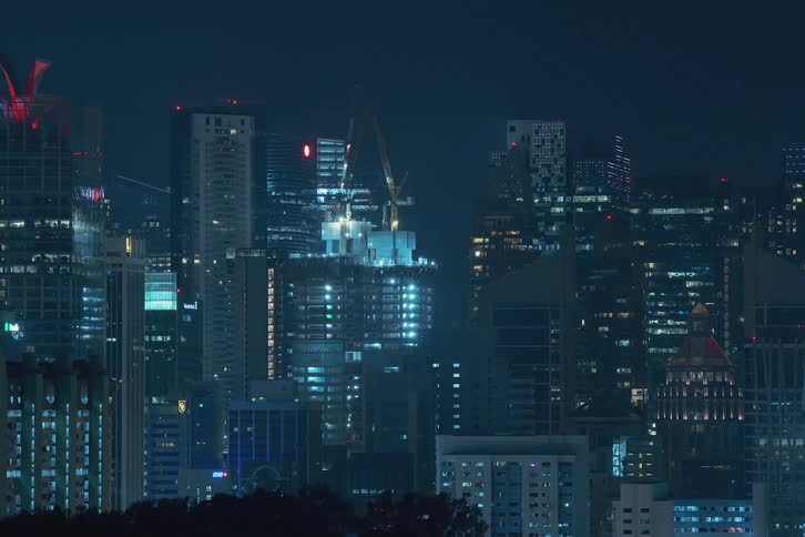 Time lapse of a skyscraper in construction on the city skyline at night