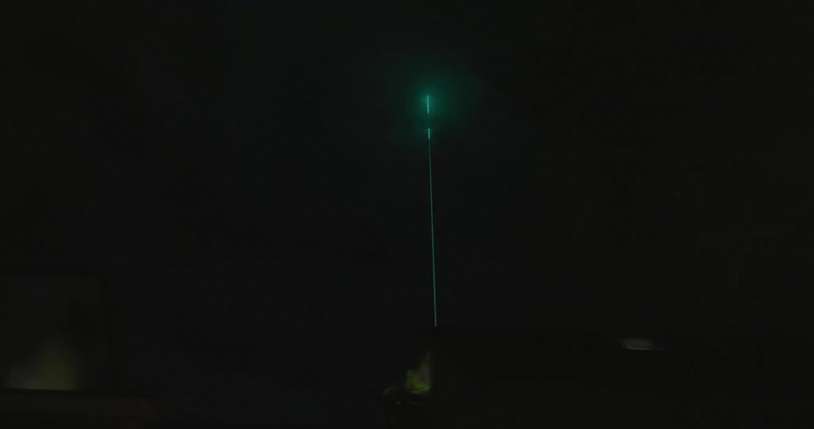 Green laser light the clouds at night