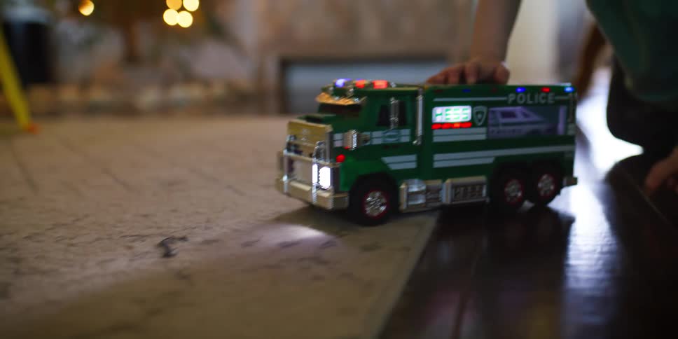 A child playing with a toy car on the living room floor
