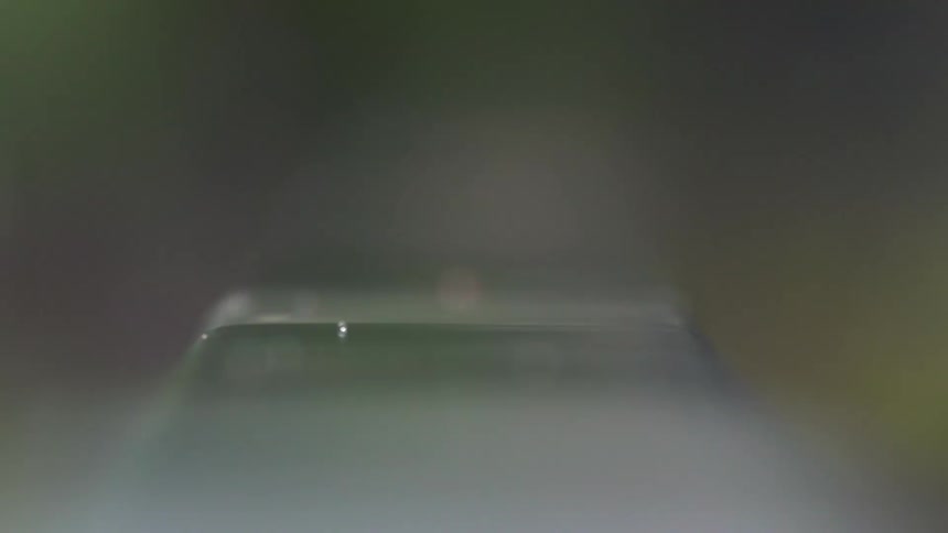 Fast raindrops falling on a blurry car