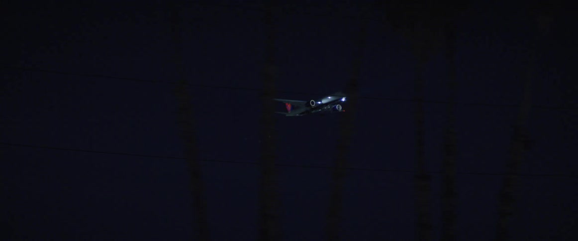 Commercial airplane landing over the city at night