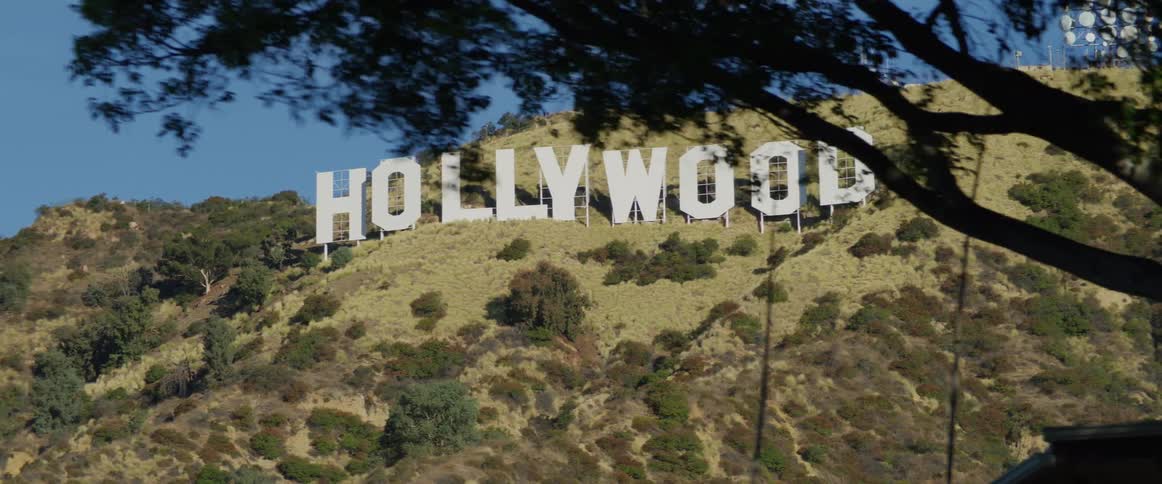The hollywood sign on a hill with small grass close to it