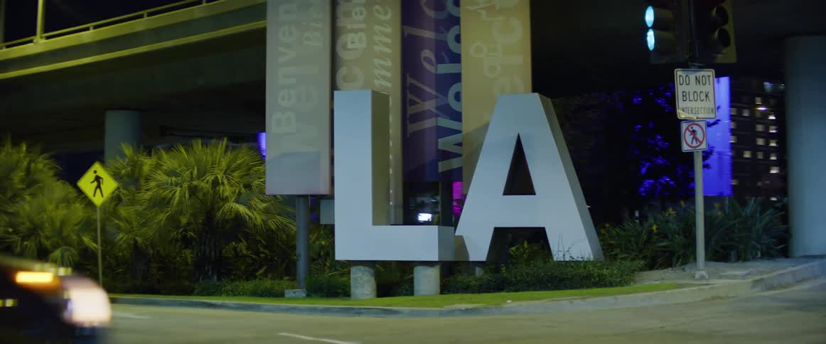Cars drive near a sign in los angeles