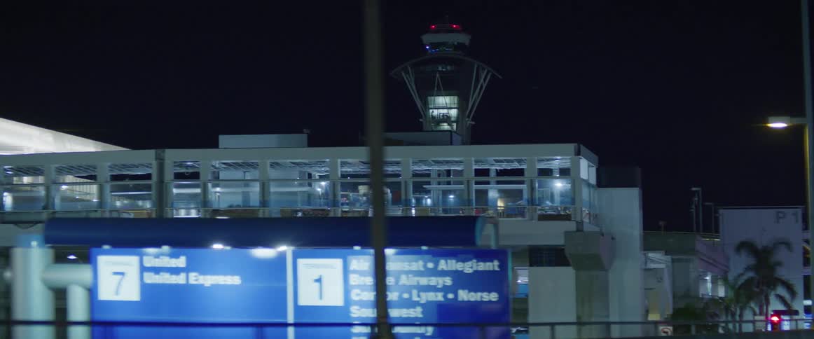 Airport in the city at night seen from a moving vehicle