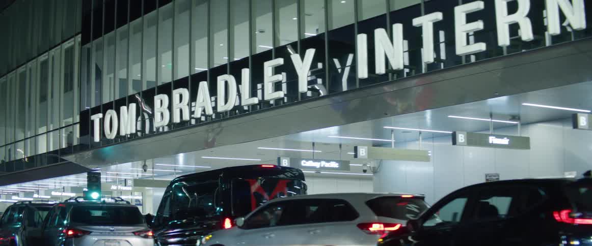 Cars are parked all along the front of the airport