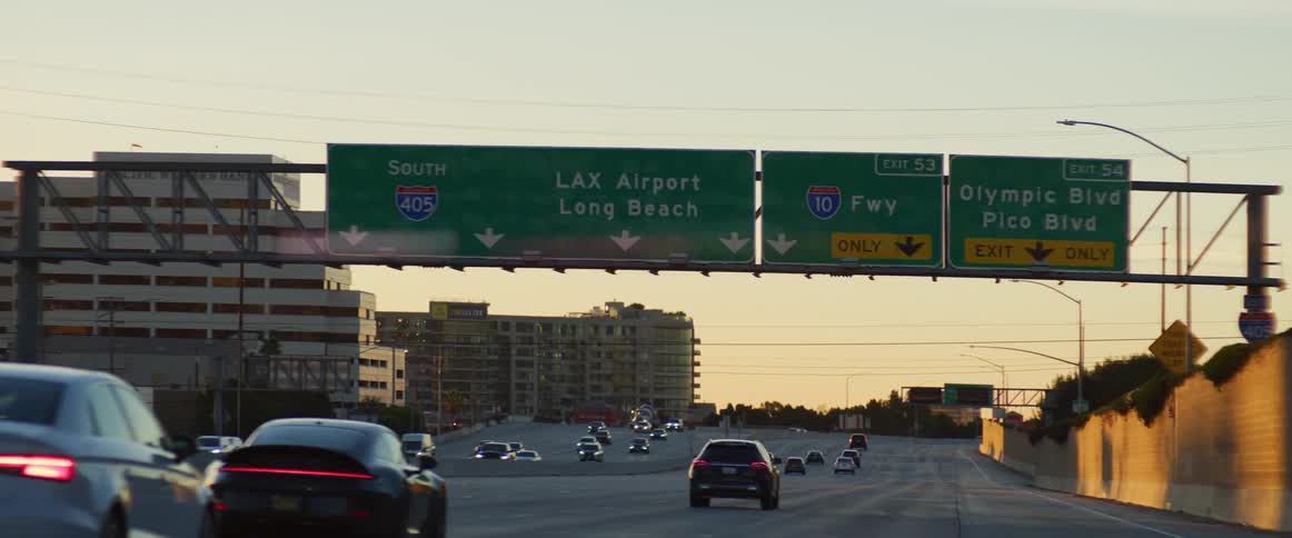 Cars driving on the freeway through the city at sunset
