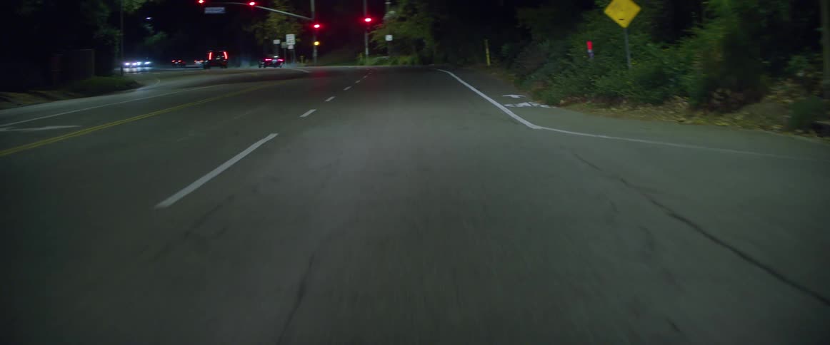 A busy highway in a suburban neighborhood at night