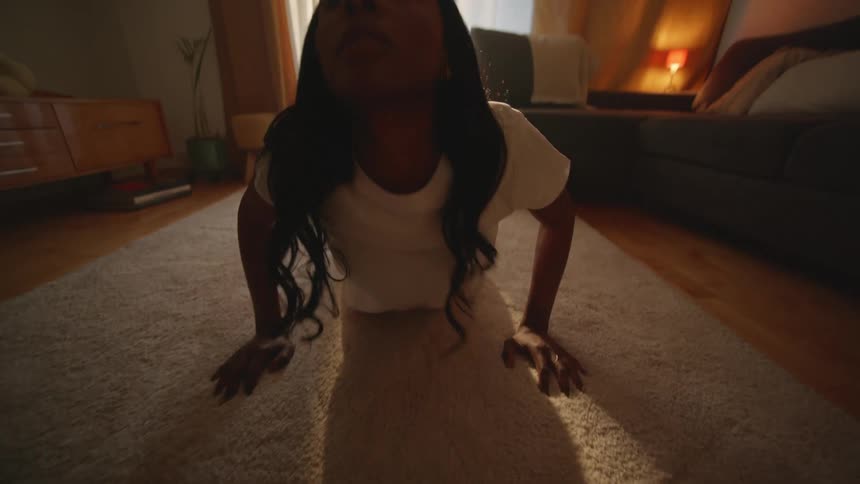 A black female doing a yoga stretch in the living room