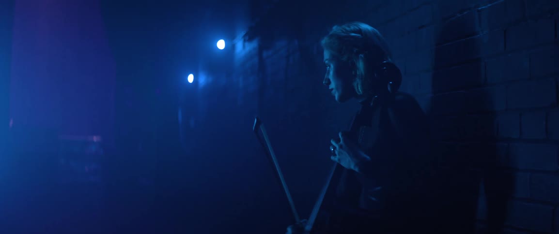 Musician anxiously practicing cello in the backstage of a theater