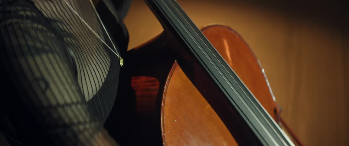 A woman onstage is playing the cello with a bow