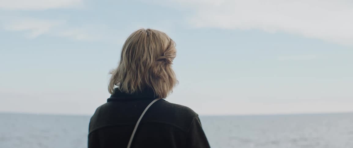 A woman is looking out over the ocean