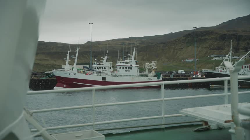Fishing boats docked near a coastal town in the mountains