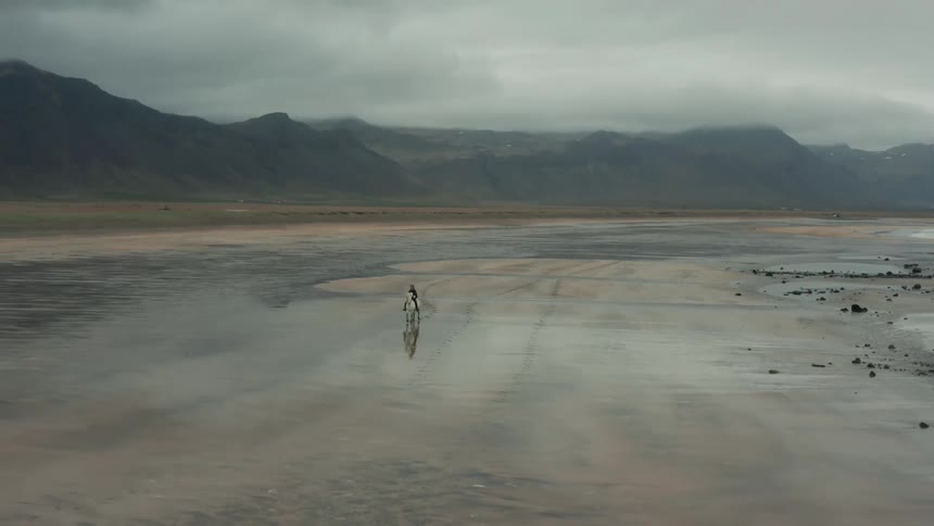 A person riding a horse on wet land