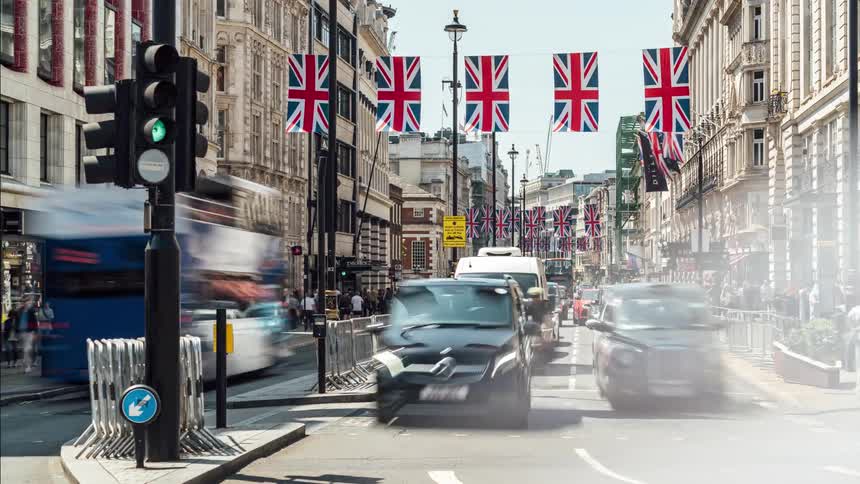 View of a street with buses cars and people moving through a metropolis in timelapse